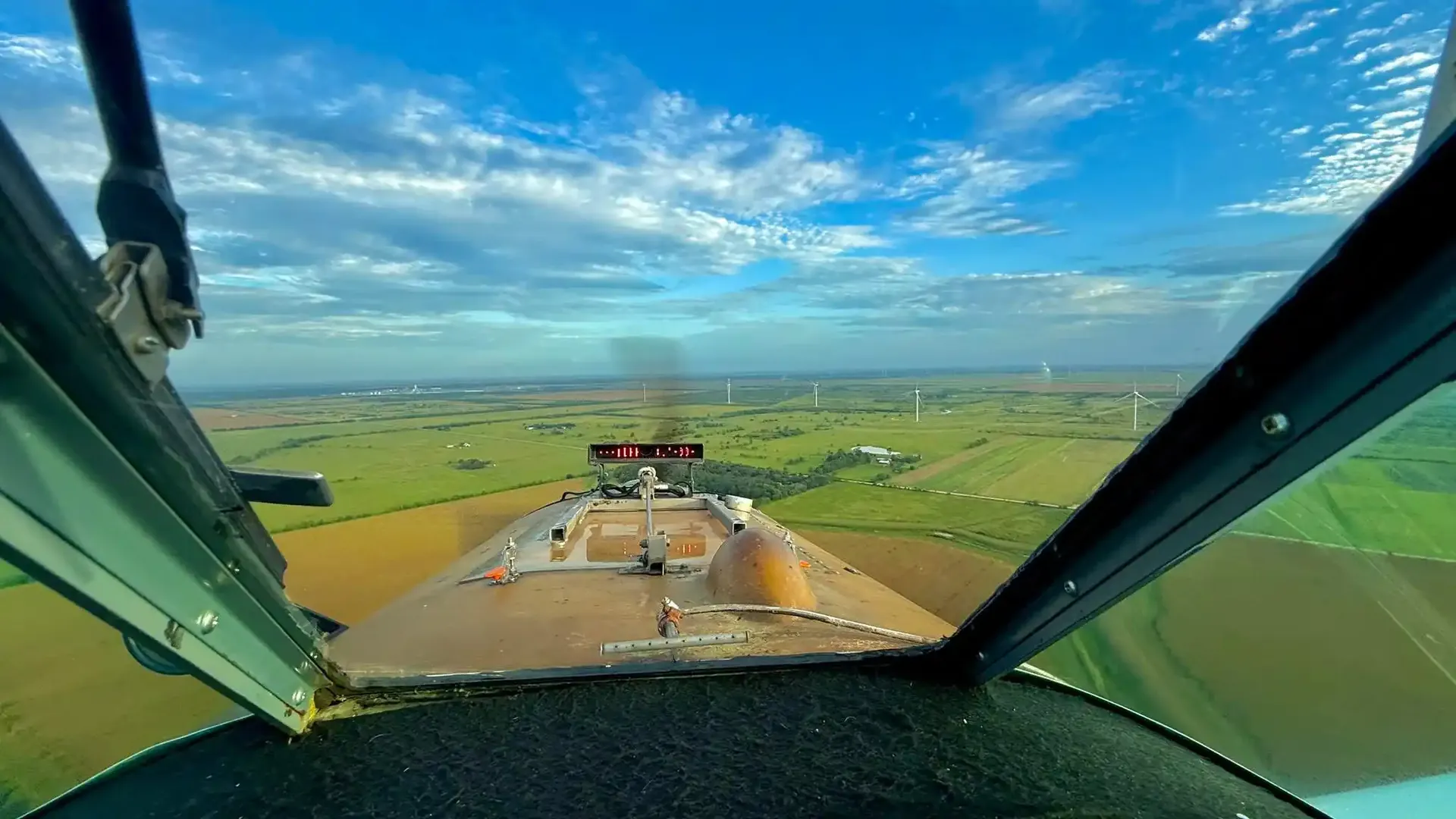 View from the cockpit of an agricultural aircraft over farmland